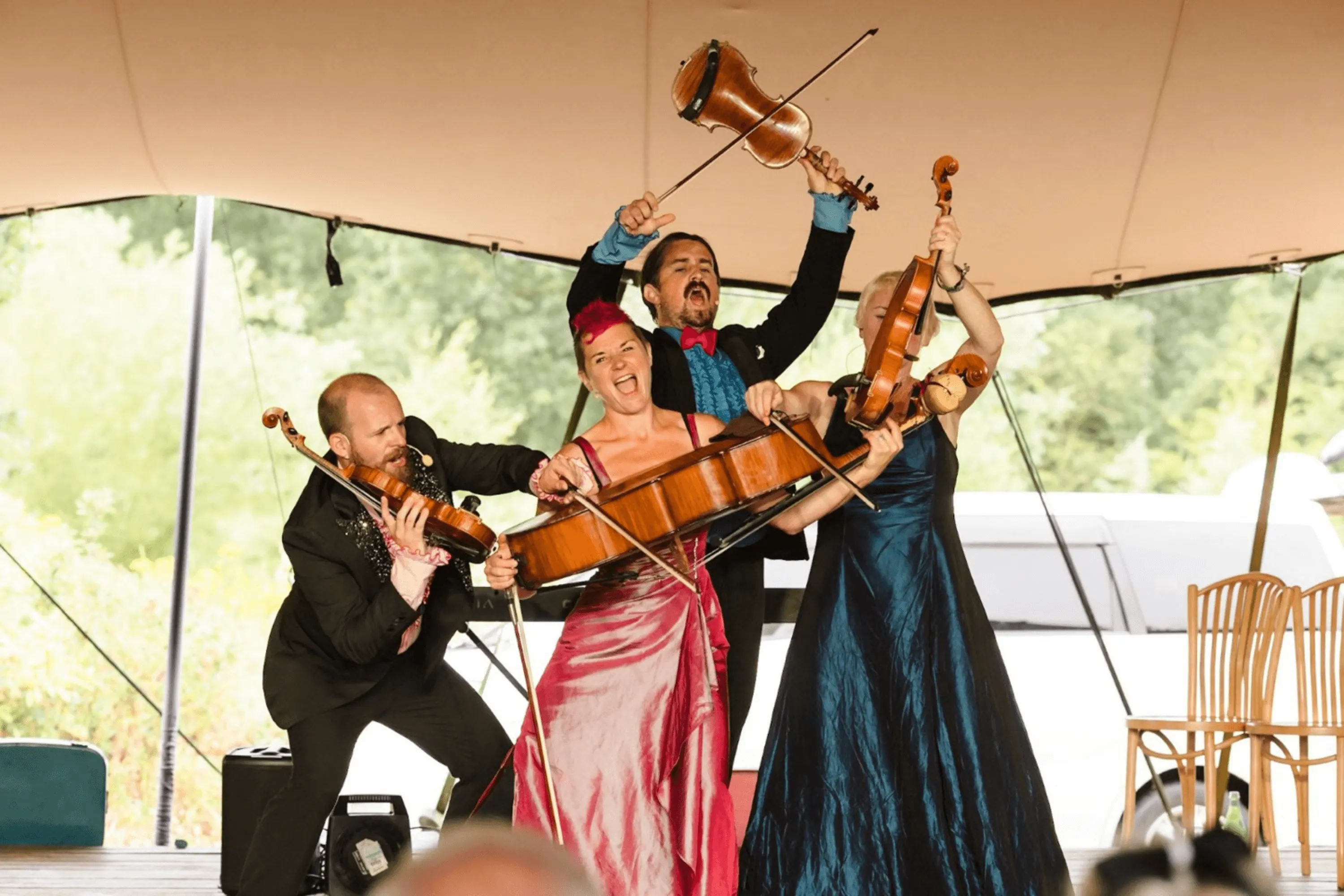 A string quartet plays energetically on an outdoor stage at Westacre Theatre.