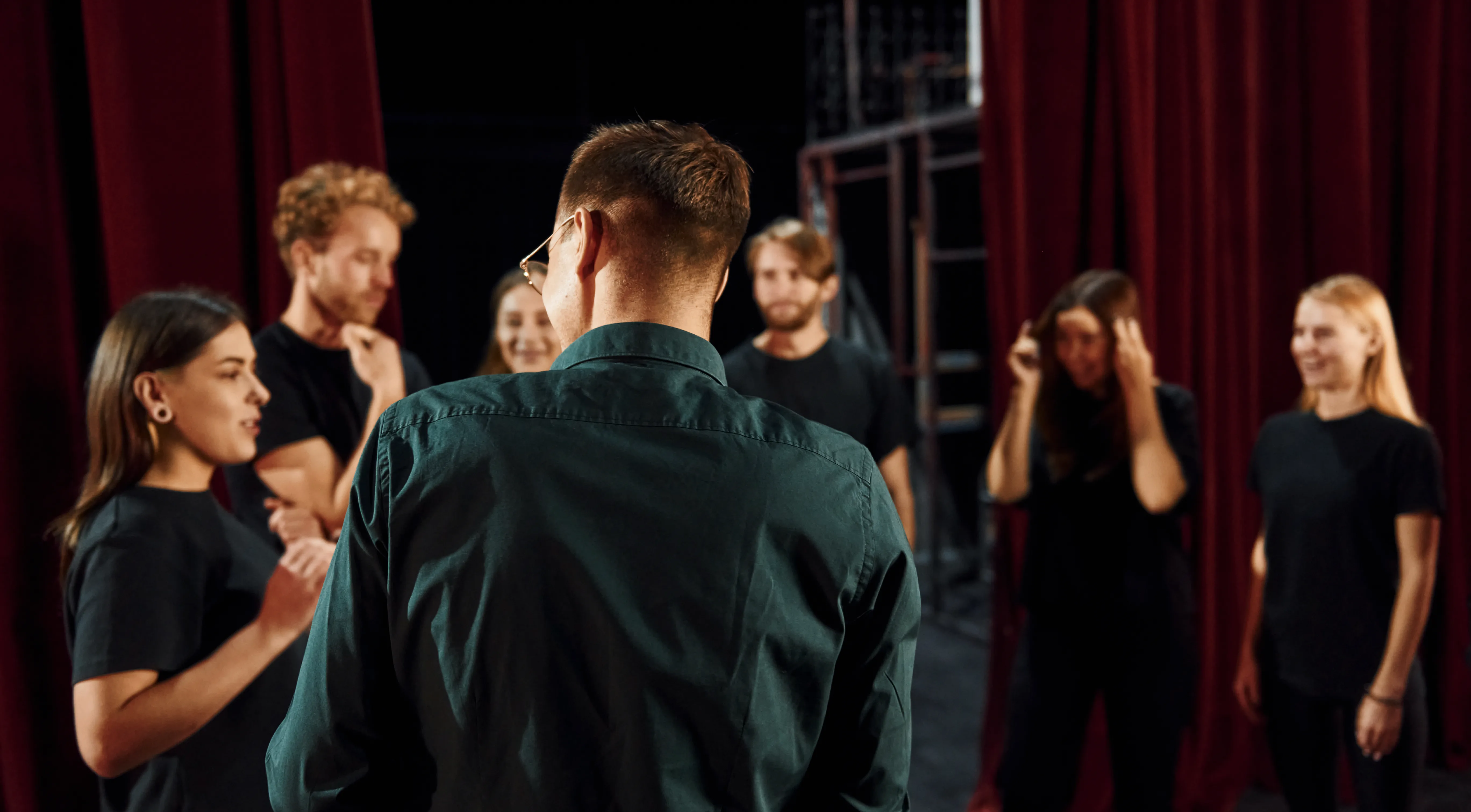 A group of people rehearsing on the theatre stage.